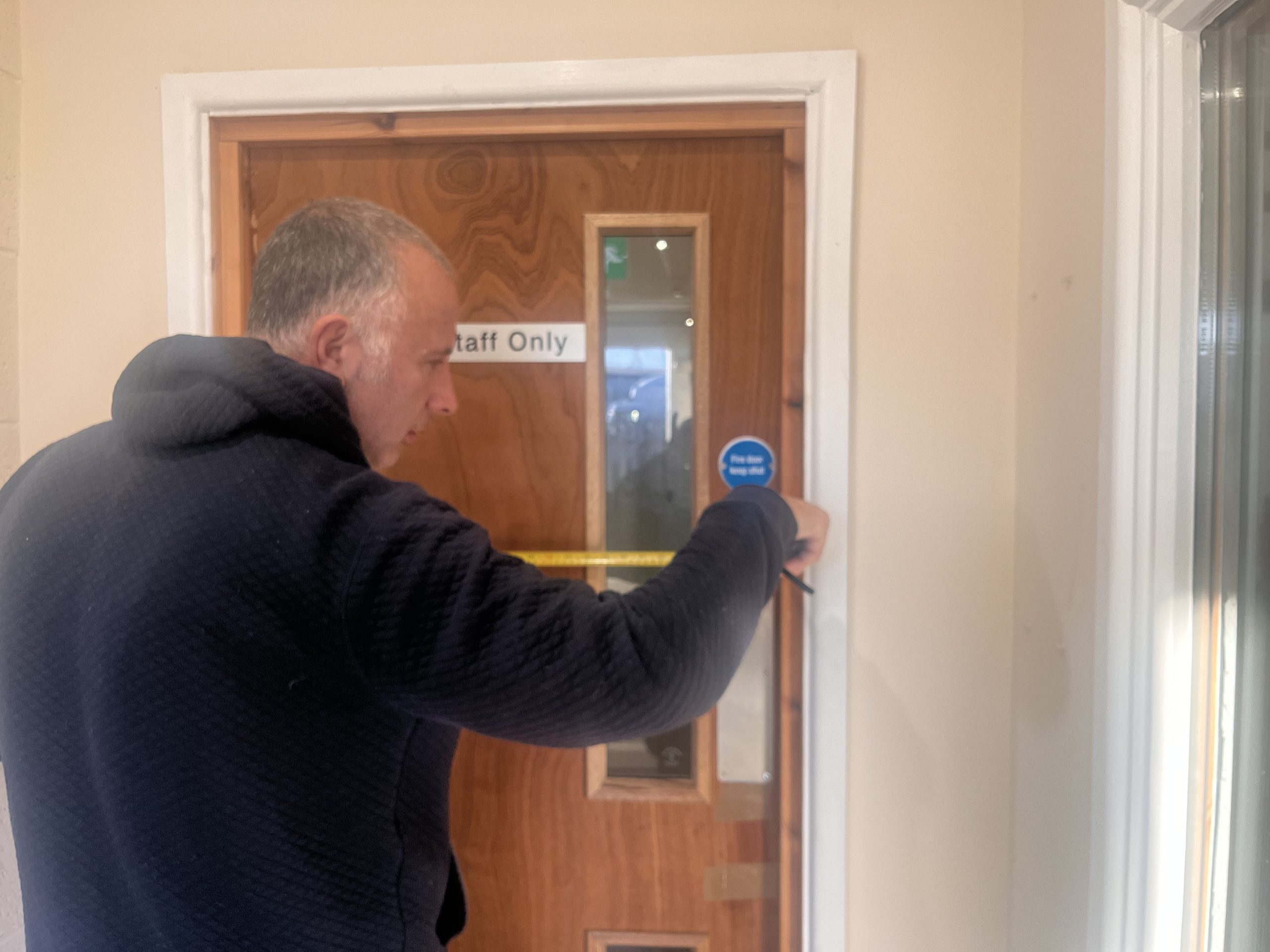 Fire risk assessor photographing a corridor during an on-site fire risk assessment in South Wales